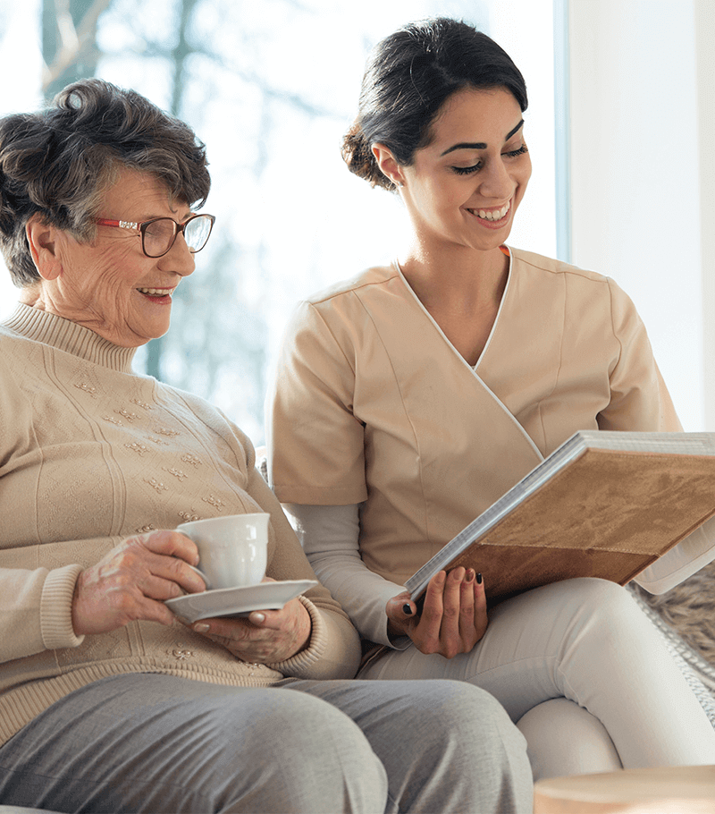 Young lady and old woman sitting together reading a book