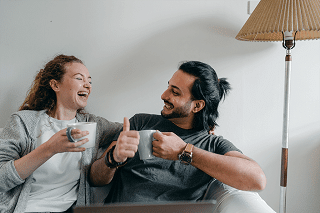 Young and happy couple sharing a cup of coffee